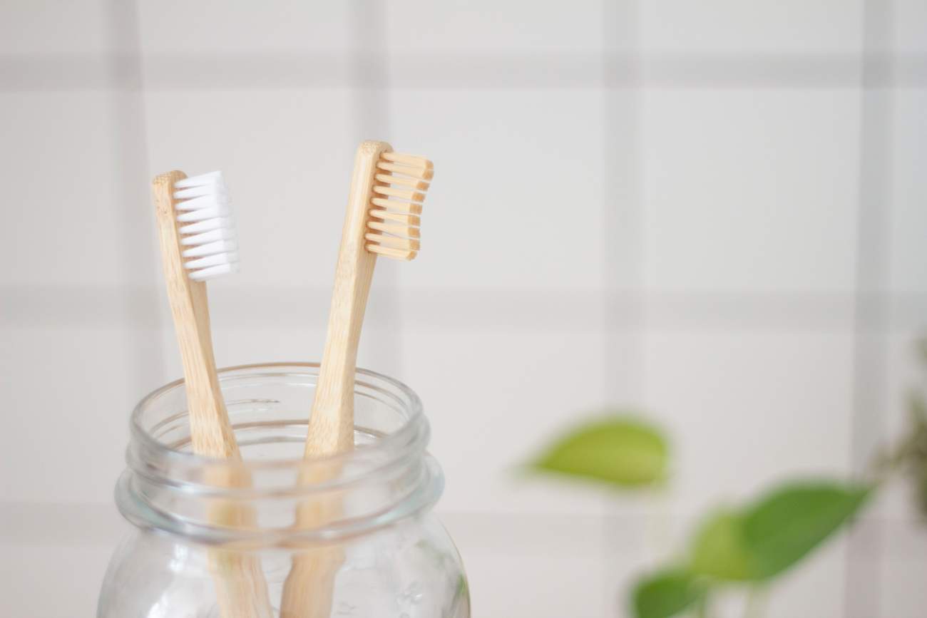 two-bamboo-toothbrushes-in-jar-in-bathroom