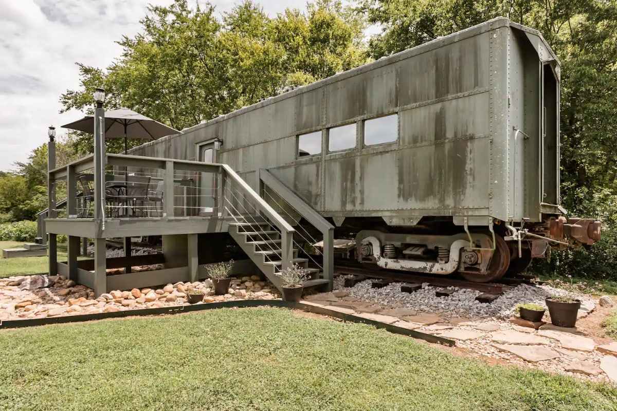 converted-WWII-train-car-with-decking-in-field