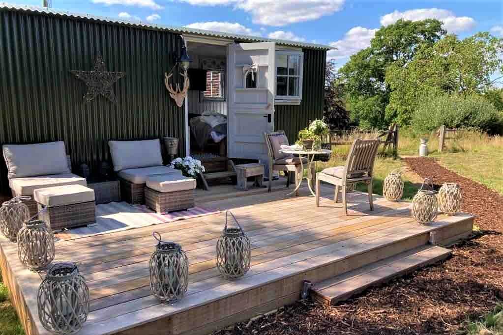 beautiful-shepherds-hut-on-decking-with-outdoor-seating