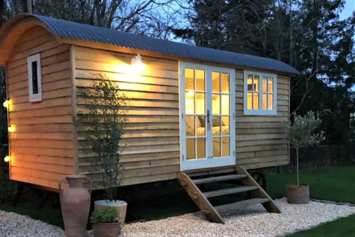 exterior-of-little-dragonfly-shepherds-hut-lit-up-in-evening
