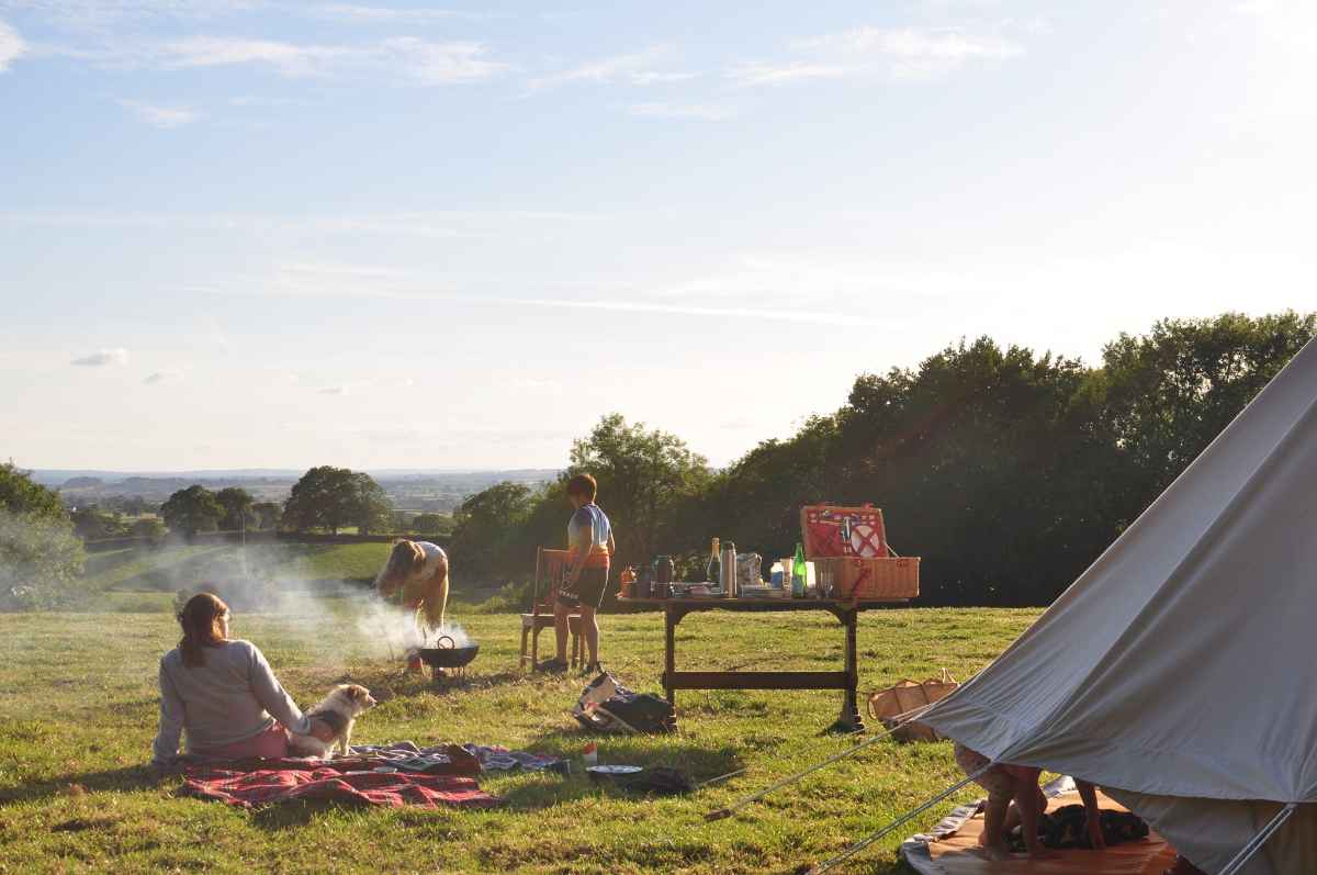 family-in-field-by-bell-tent-at-gold-hill-glamping