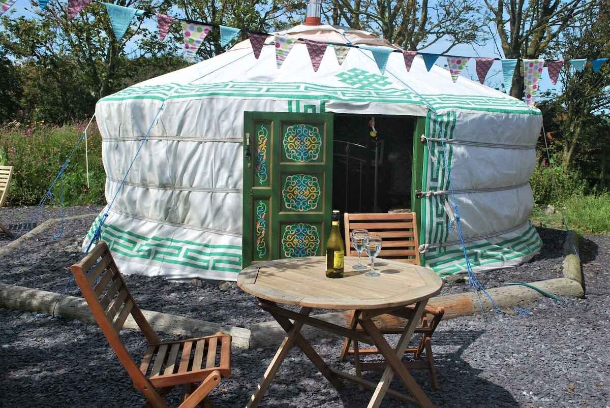 rhoscolyn-yurt-with-bunting-and-outdoor-furniture