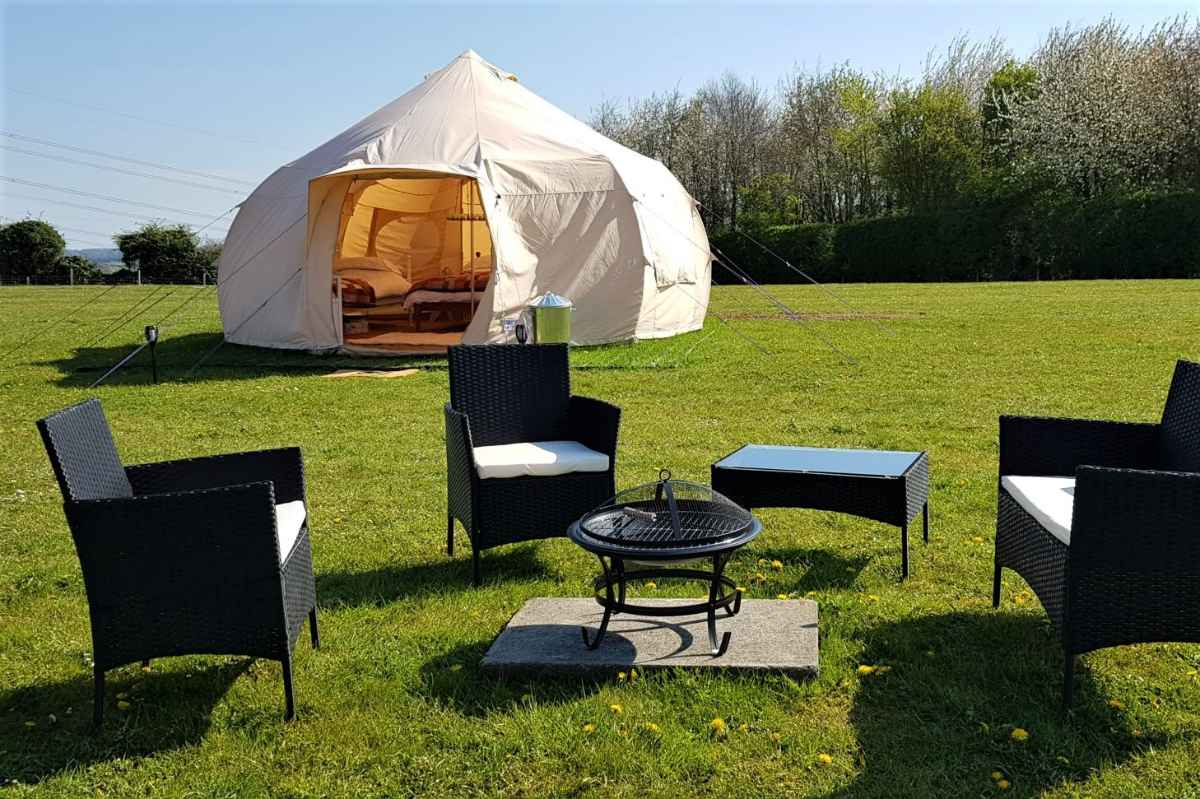rolling-fields-glamping-luna-tent-with-outdoor-seating-in-field