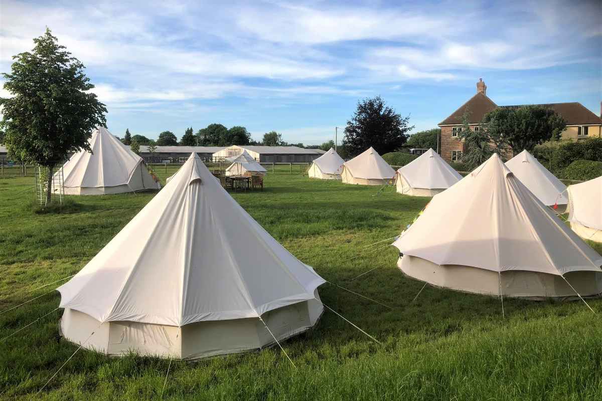 stonehenge-campsite-bell-tents-in-field-on-sunny-day