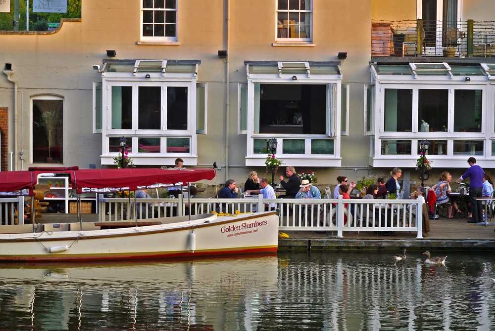 boat-in-front-of-the-folly-restaurant-on-river