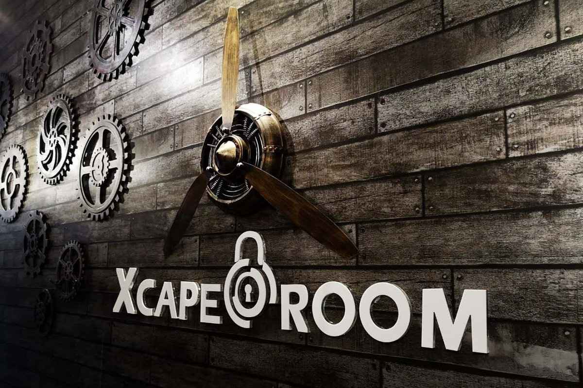 xcape-room-sign-with-cogs-on-wall