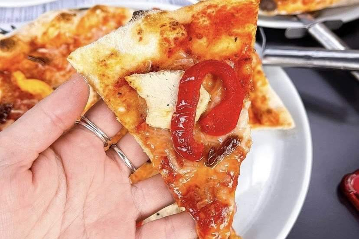 prezzo-slice-of-vegan-pizza-in-a-hand