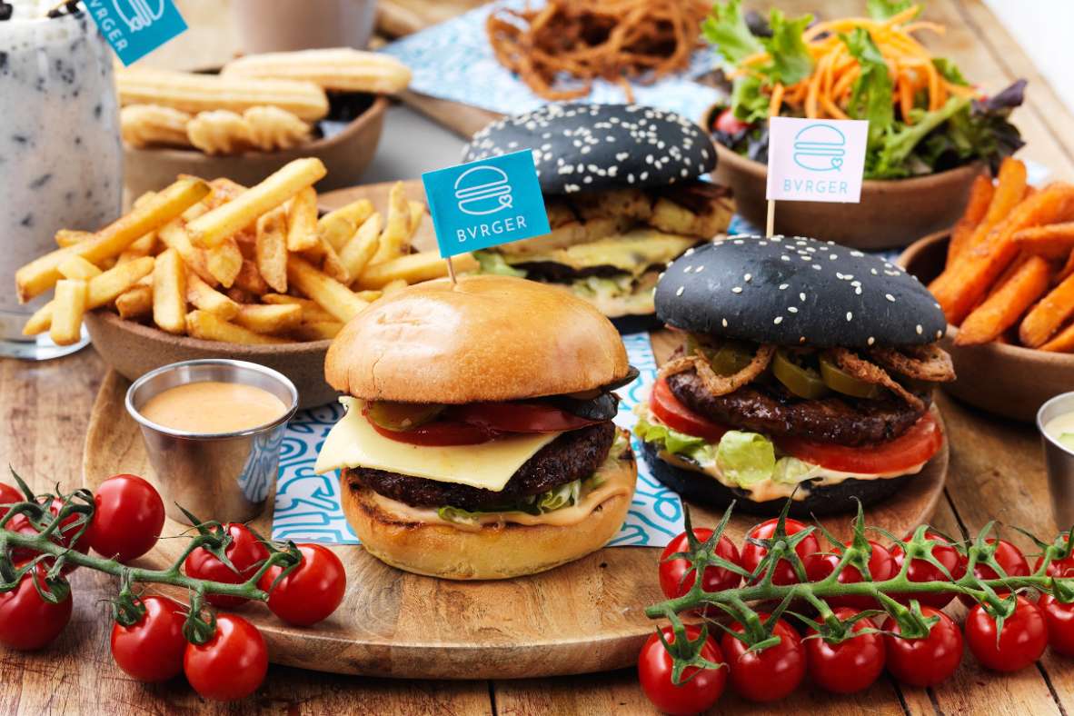vegan-burgers-fries-and-tomatoes-on-wooden-board-bvrger