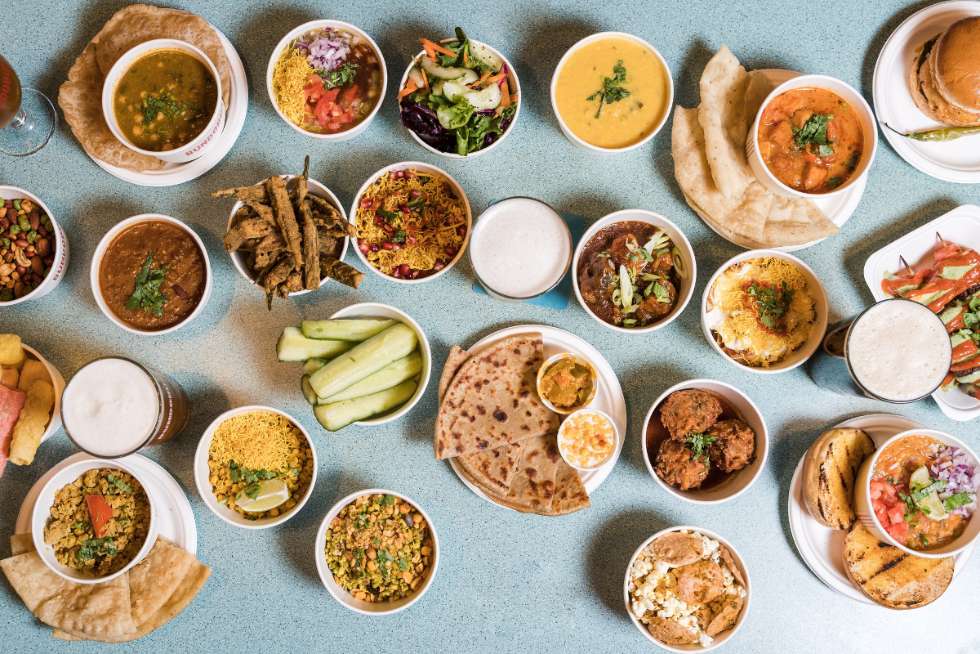 selection-of-curries-sides-and-drinks-on-table-at-bundobust