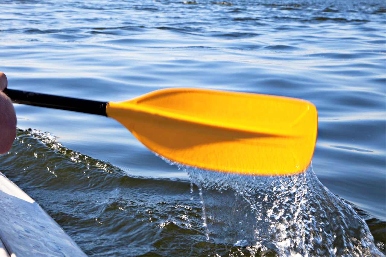 kayaker-lifting-yellow-oar-out-of-water