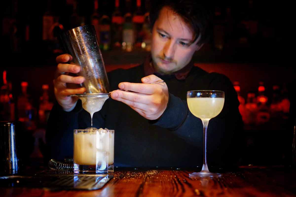 man-making-cocktails-behind-bar-of-pennyroyal-bar