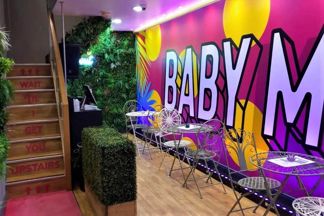 tables-next-to-colourful-wall-in-baby-m-bar