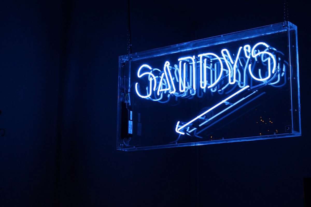 neon-sign-pointing-to-sandys-piano-bar