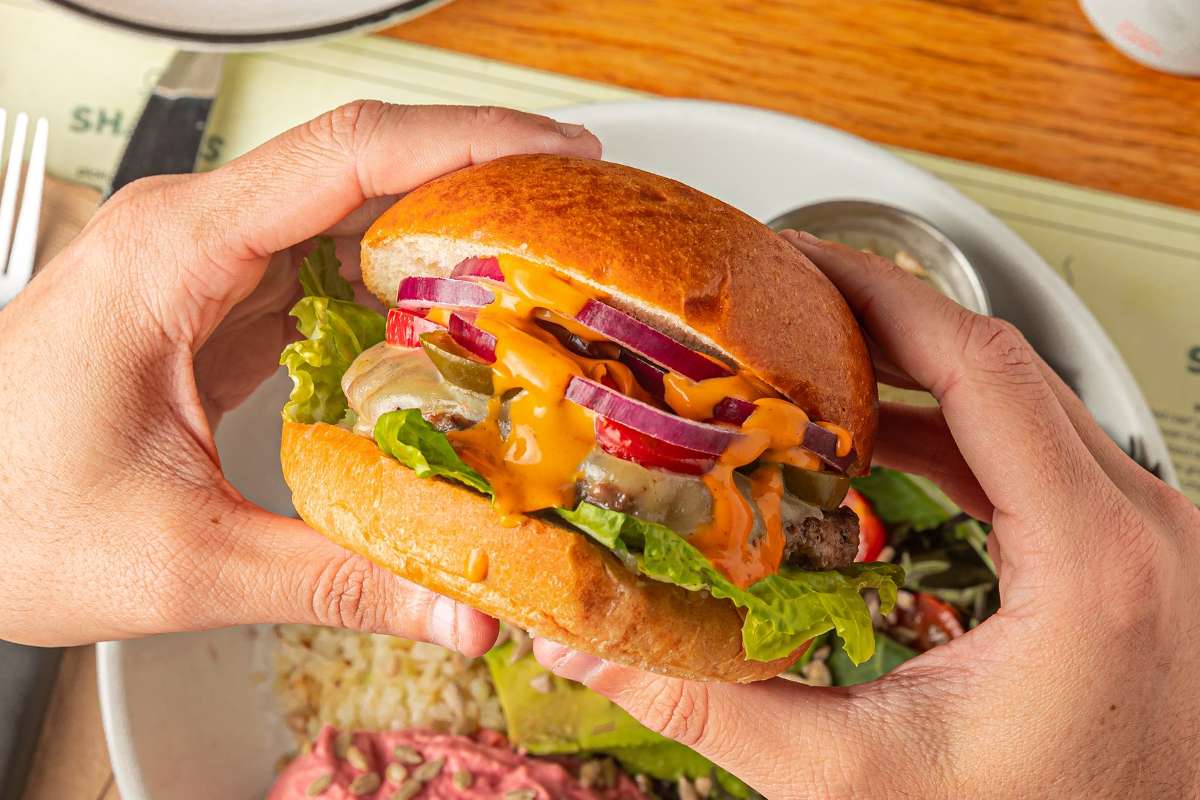 burger-in-hands-over-plate-at-bareburger-vegan-burgers-nyc