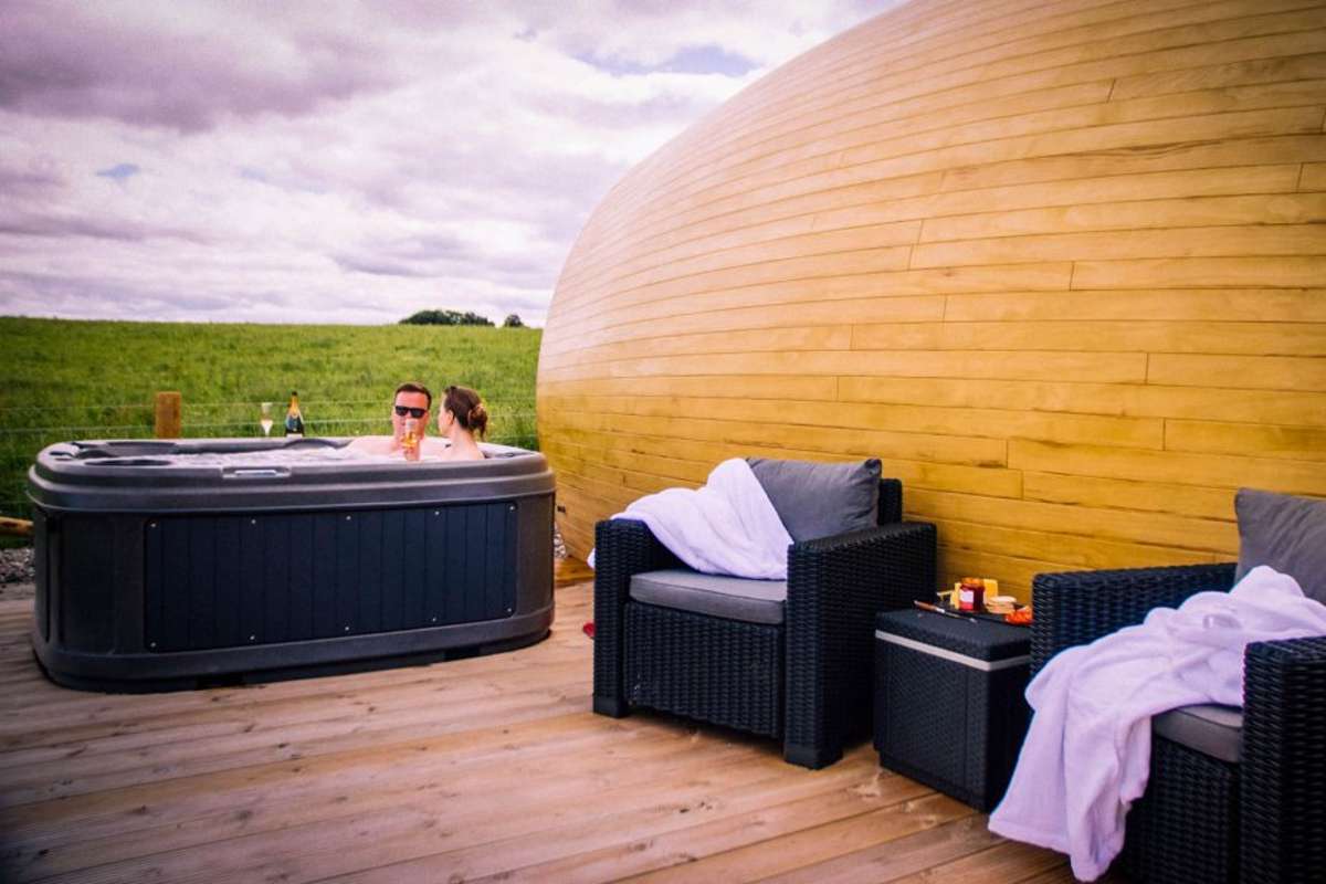 people-in-the-hot-tub-outside-the-luxury-hideaway-pods-in-the-daytime