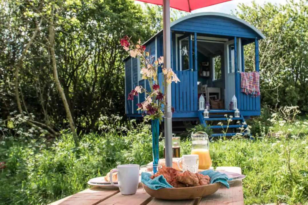 exterior-of-seren-wagon-with-breakfast-table-in-the-daytime-glamping-northamptonshire