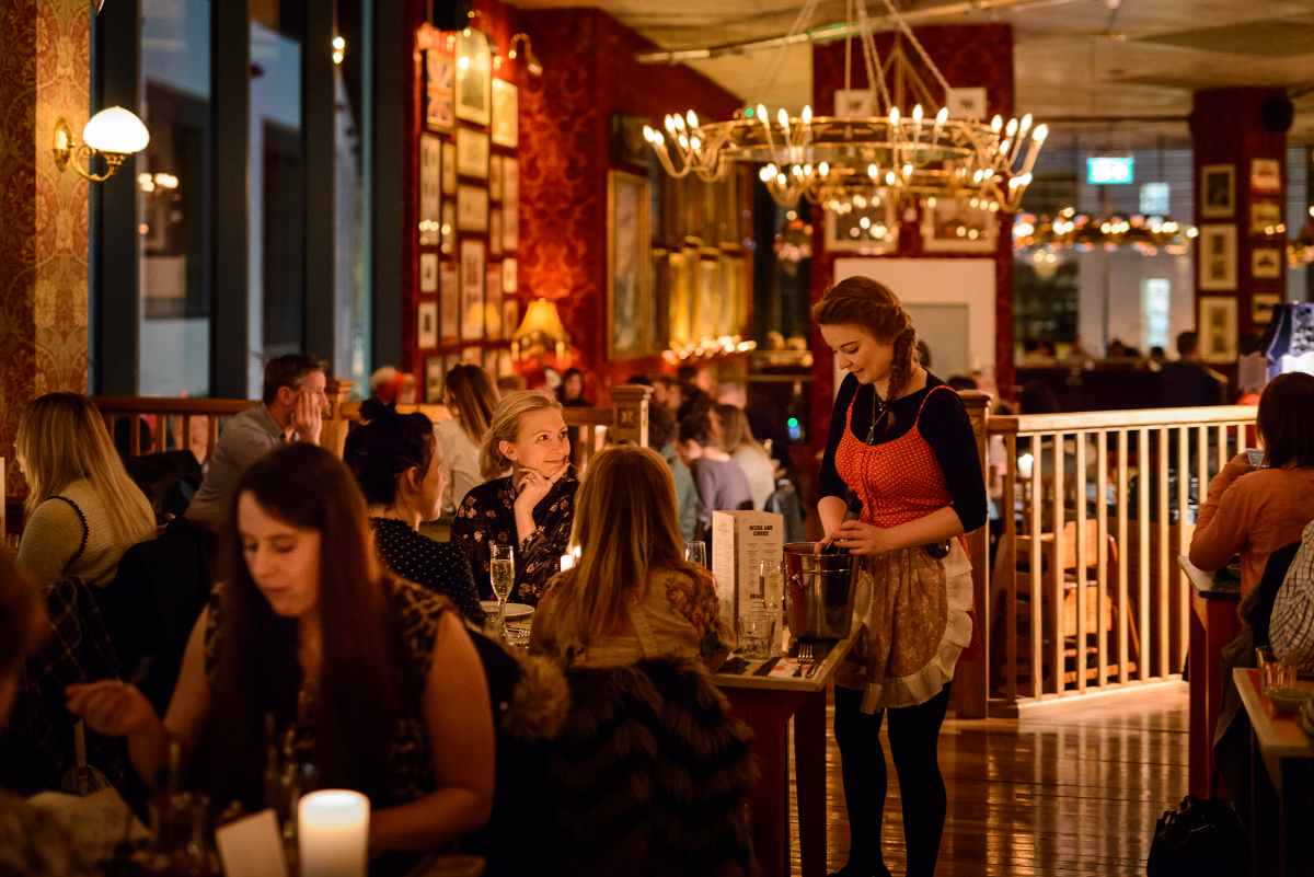 waitress-serving-table-in-cosy-club-restaurant-at-night
